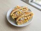 Wedges of thick folded apam balik with a crushed peanut, sugar and sweetcorn filling on a white plate