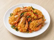 Butter prawns: shell-on prawns covered in golden egg floss with curry leaves and sliced red chilli on a white plate