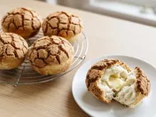 Mexican coffee buns: round golden buns with a crisp, crackled brown coffee crust, one torn open to show the soft buttery inside